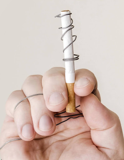 Wellbrook Recovery shows a hand holding a cigarette caught in wire symbolizing why people do drugs