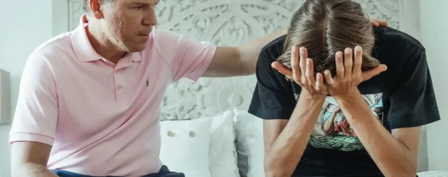 Man supporting teenage boy through addiction recovery.