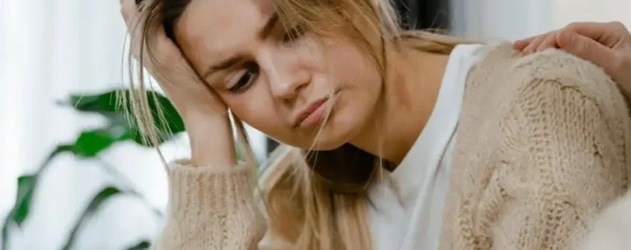 Distressed woman receiving Internal Family Systems Therapy (IFS) for addictions during a supportive session.