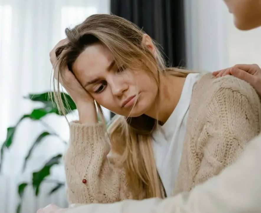 Distressed woman receiving Internal Family Systems Therapy (IFS) for addictions during a supportive session.