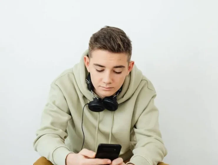 Boy in rehab using phone, illustrating the common question: Can you have your phone in rehab?