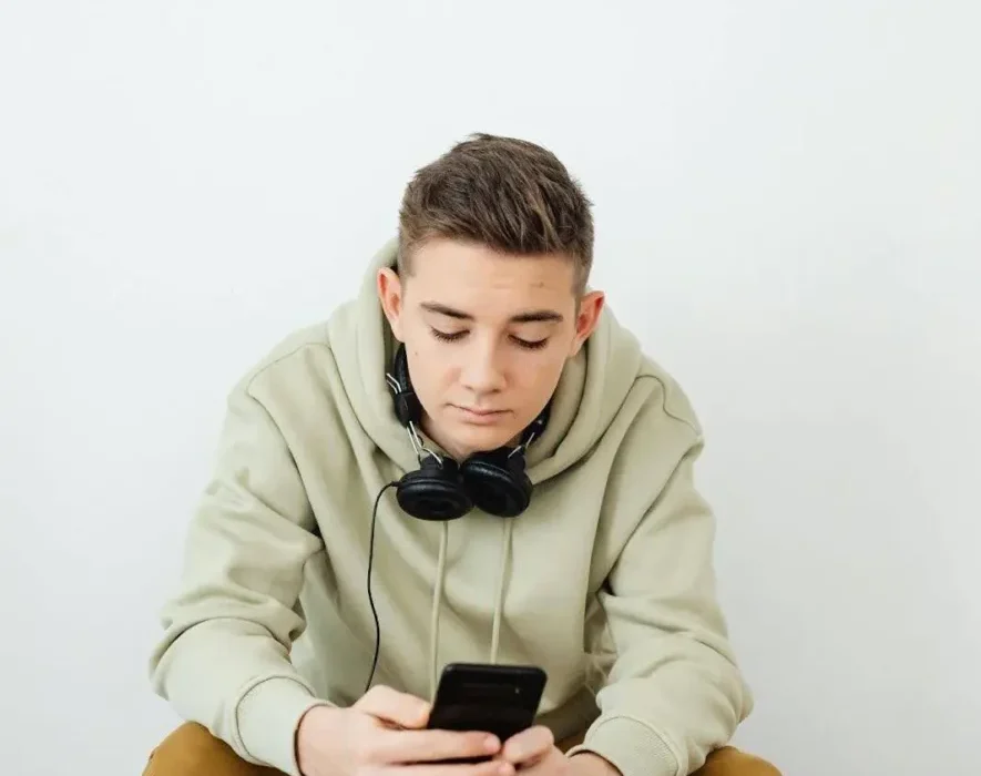 Boy in rehab using phone, illustrating the common question: Can you have your phone in rehab?