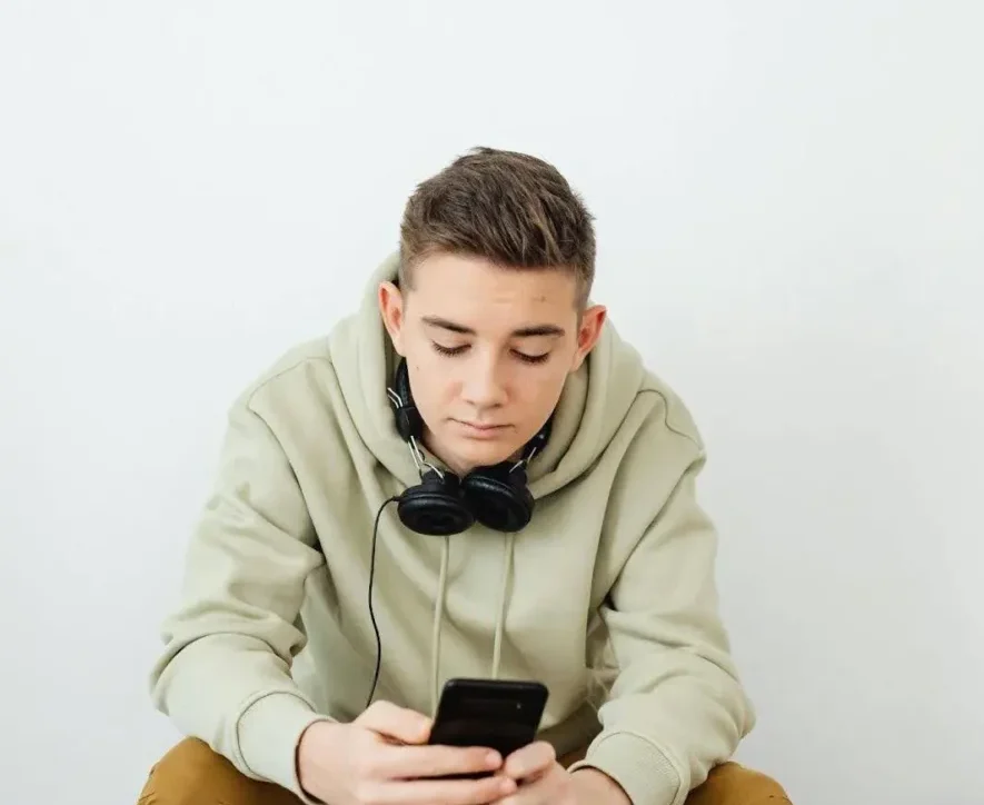 Boy in rehab using phone, illustrating the common question: Can you have your phone in rehab?