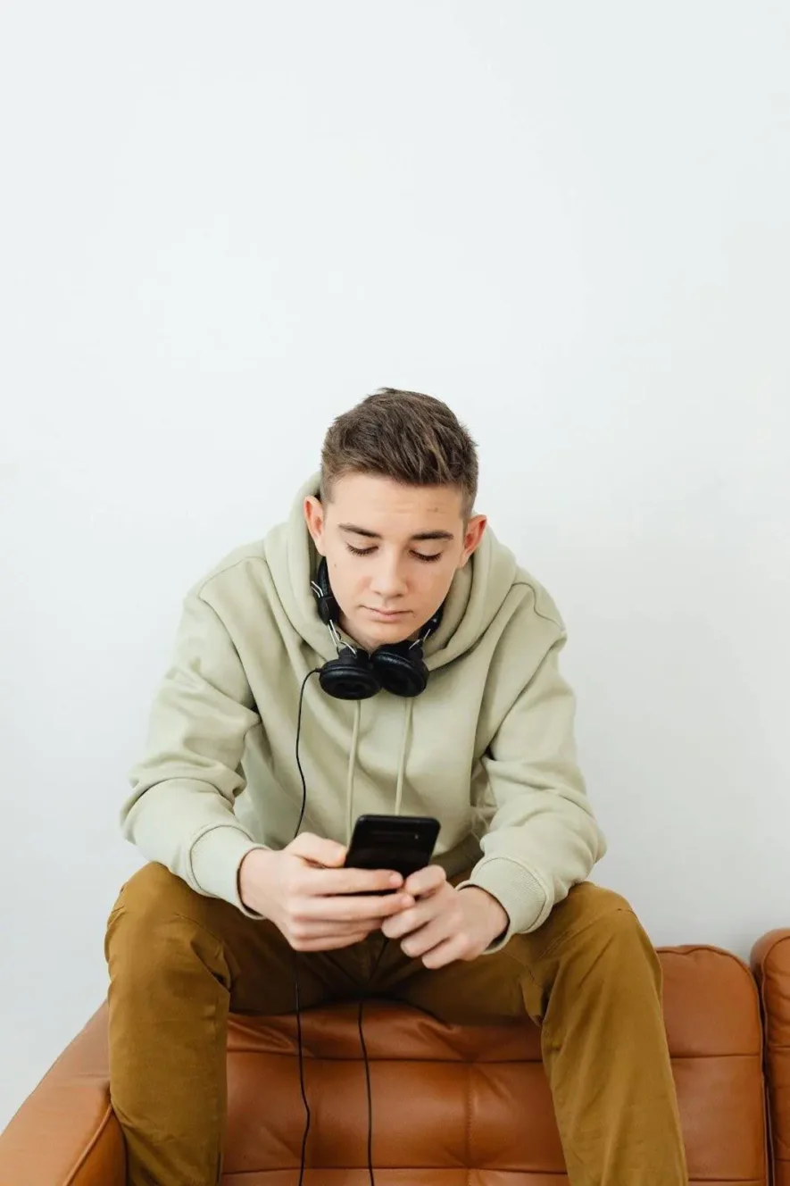 Boy in rehab using phone, illustrating the common question: Can you have your phone in rehab?