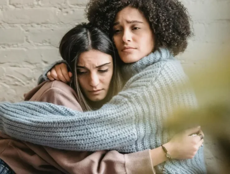 image of two women hugging, illustrating the support REBT for addiction provides to individuals in recovery.