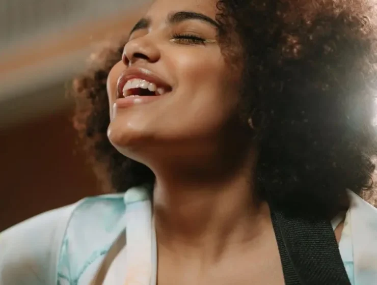 A woman engaged in music therapy for addiction, using singing and guitar to aid recovery.