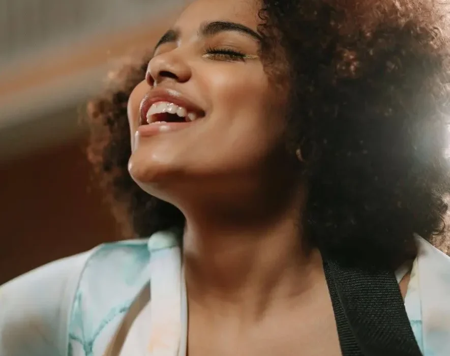 A woman engaged in music therapy for addiction, using singing and guitar to aid recovery.