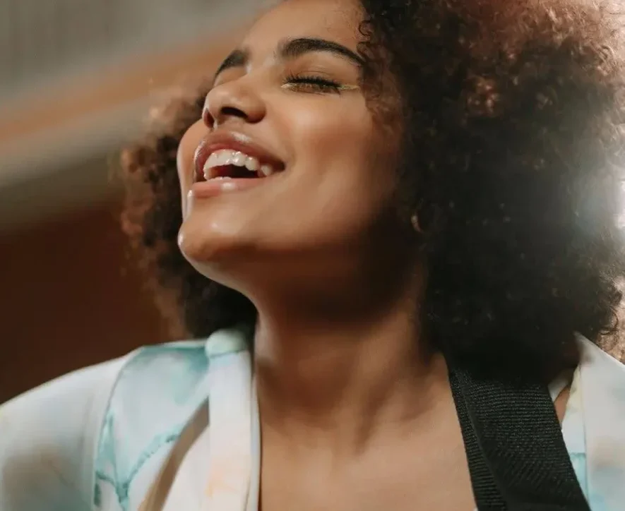 A woman engaged in music therapy for addiction, using singing and guitar to aid recovery.