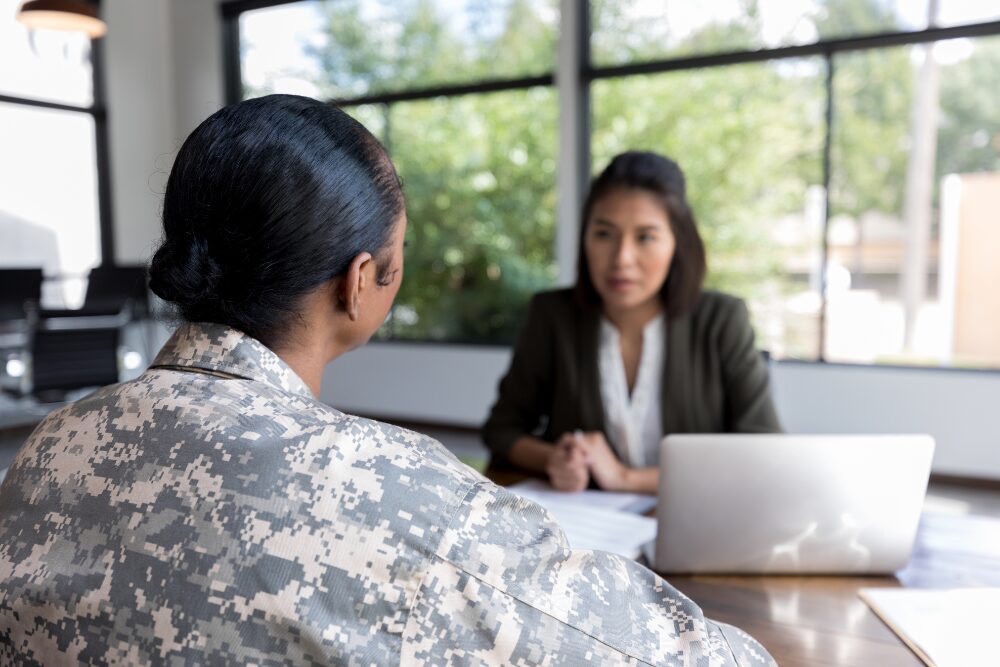 Female veteran speaks privately with counselor, symbolizing confidentiality laws protecting veteran healthcare and legal rights.