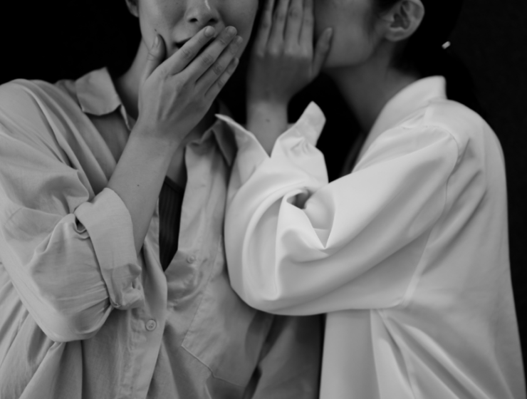 Two individuals whisper in private, symbolizing the importance of confidentiality and trust in rehab settings.