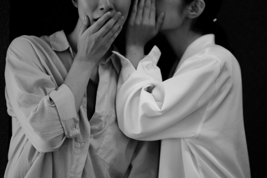 Two individuals whisper in private, symbolizing the importance of confidentiality and trust in rehab settings.