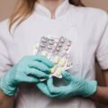 Healthcare professional holding packs of prescription medication, representing detox medications used in drug and alcohol treatment.