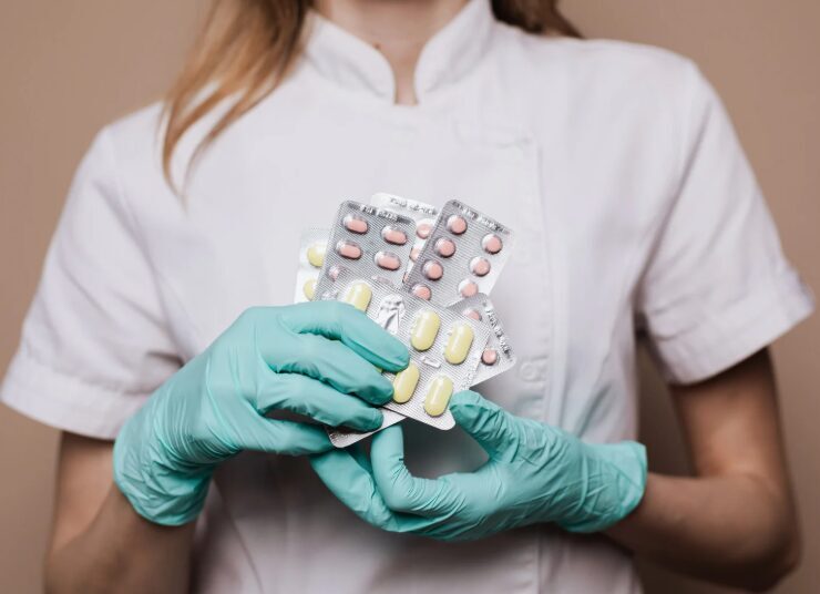 Healthcare professional holding packs of prescription medication, representing detox medications used in drug and alcohol treatment.