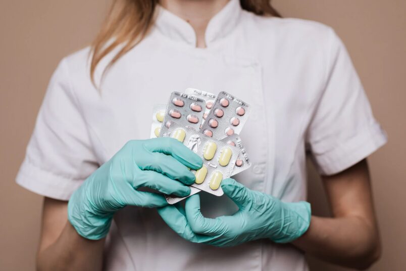 Healthcare professional holding packs of prescription medication, representing detox medications used in drug and alcohol treatment.