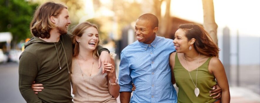 four friends walking outside together having a good time