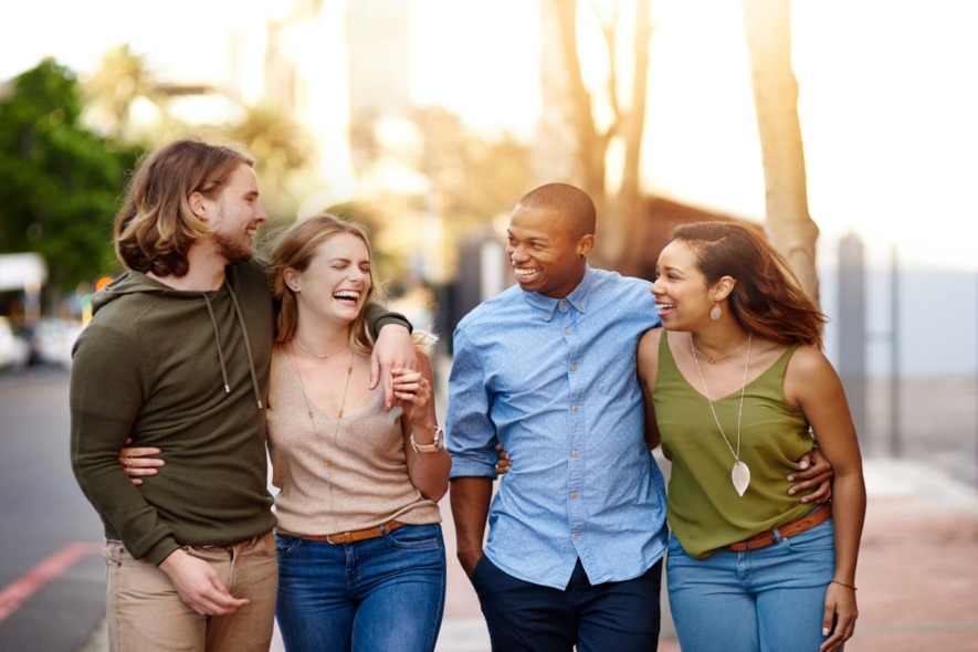 four friends walking outside together having a good time