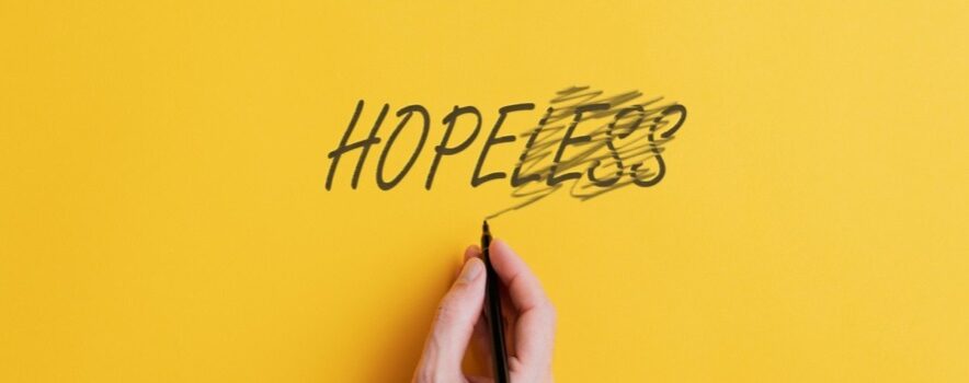 hand crossing out "less" and making it say "hope" instead of "hopeless"