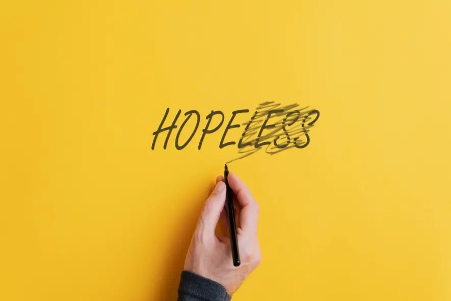 hand crossing out "less" and making it say "hope" instead of "hopeless"
