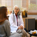 Senior female psychologist listening to female patient during a session in her office. Mental health concept.